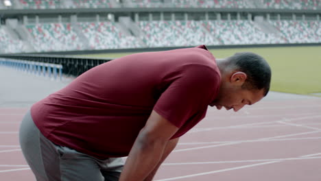 Handporträt-Eines-Afroamerikanischen-Schwarzen-Mannes,-Der-Nach-Einem-Lauf-Auf-Einer-Leeren-Stadionstrecke-Am-Frühen-Morgen-Luft-Holt.-Aufgenommen-Mit-Einem-Anamorphotischen-Objektiv